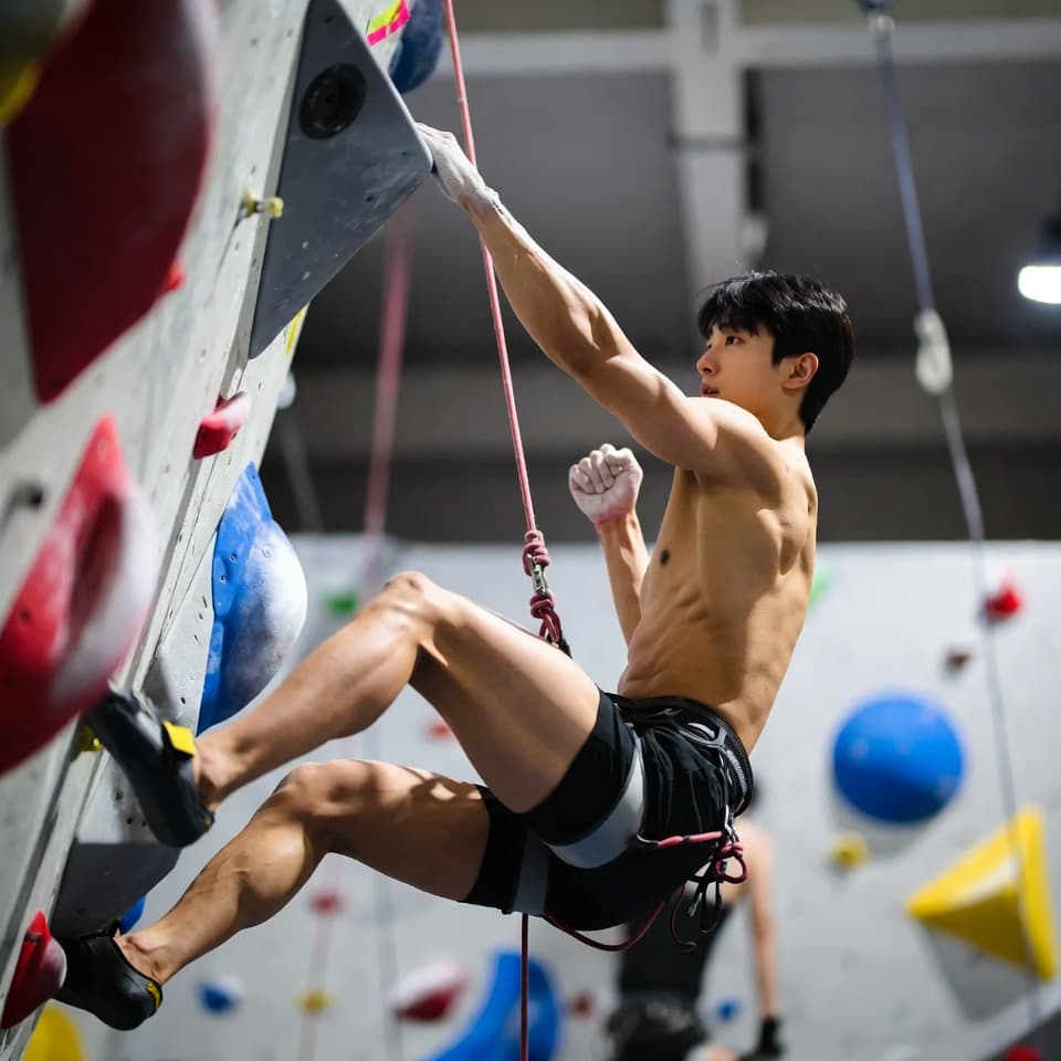 실내 클라이밍 벽을 오르는 클라이머